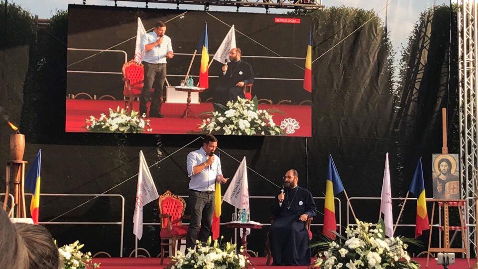 Daniel Buzduga și părintele Necula, în deschiderea concertului Holograf. FOTO: Facebook / Daniel Buzdugan